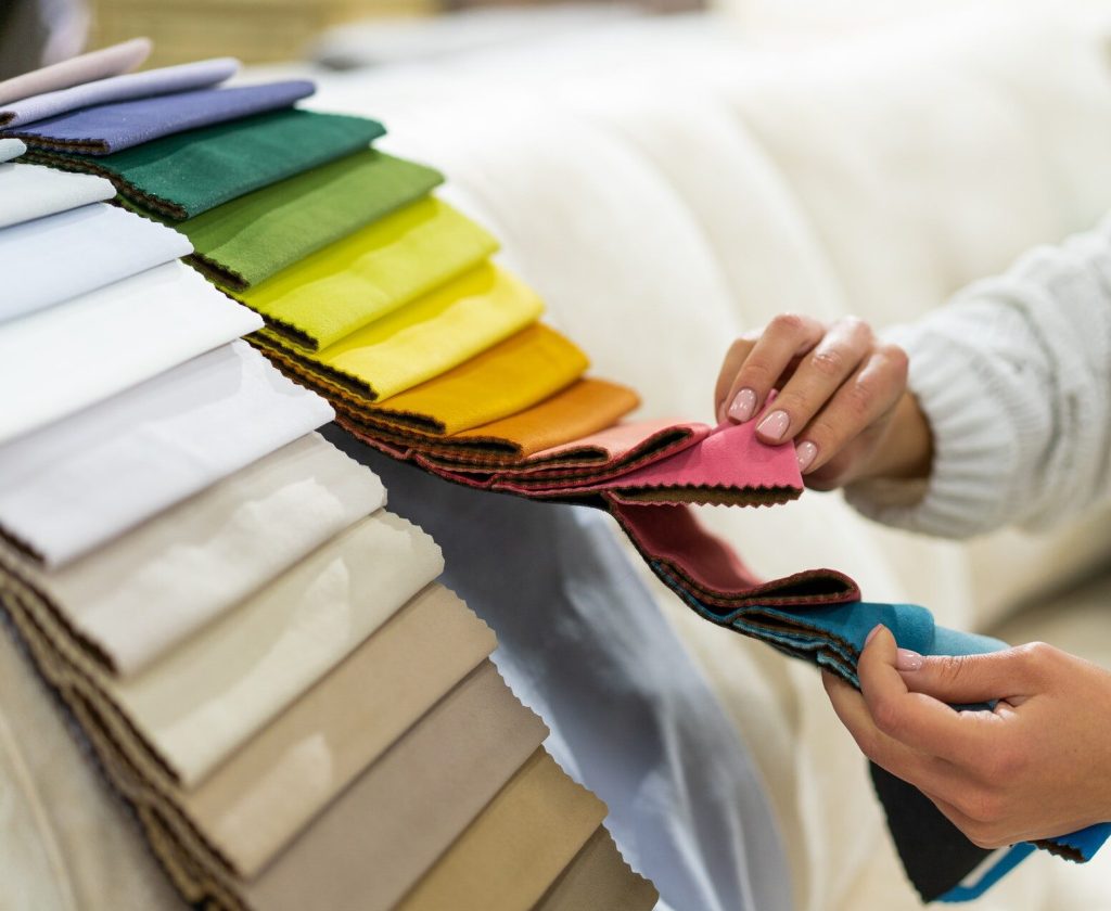 the-woman-chooses-the-fabric-on-the-sofa-textile-industry-background-tissue-catalog.jpg